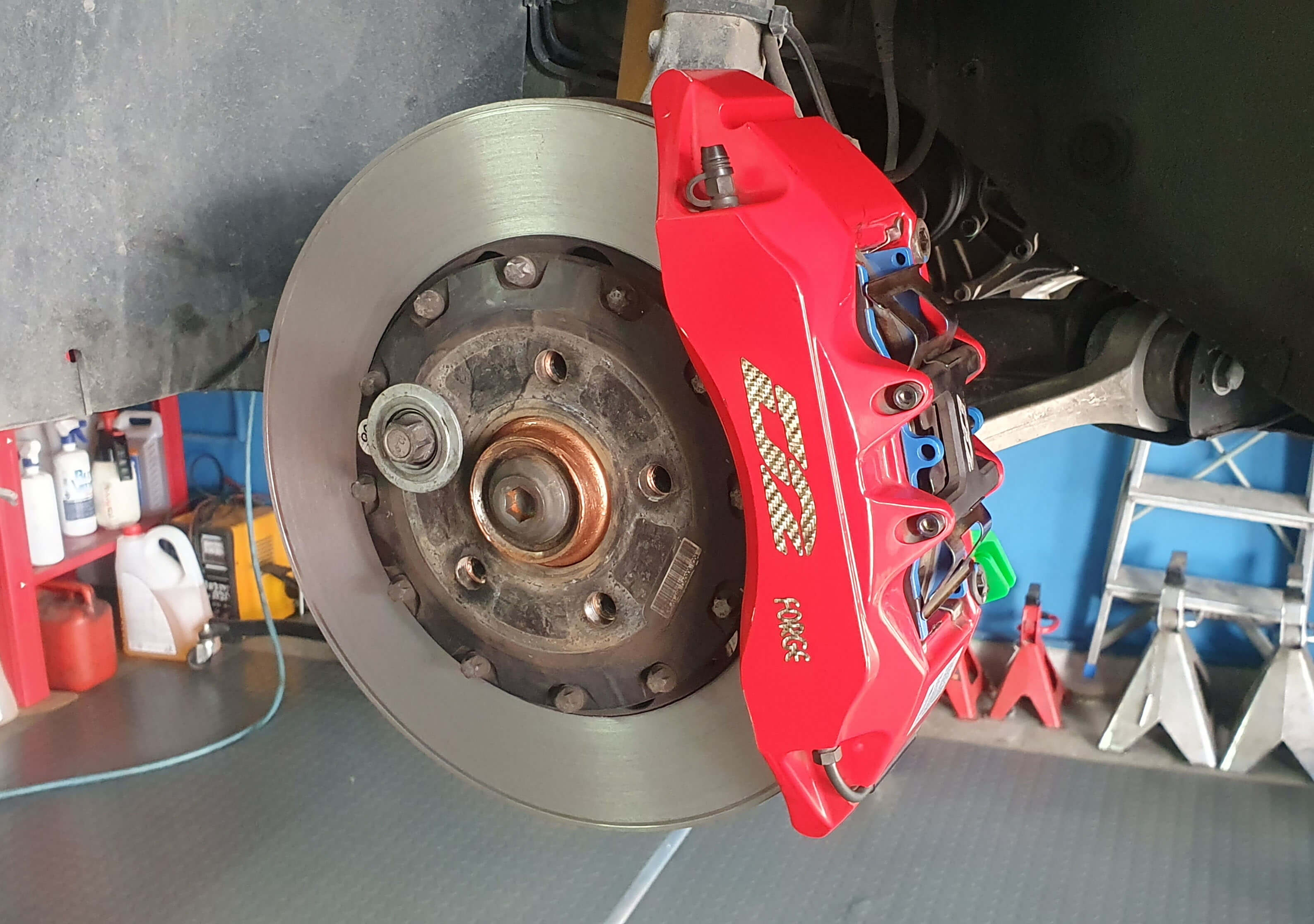 Κόκκινη ξαπίστονη δαγκάνα racing. Η δαγκάνα, αφού έχει αφαιρεθεί και επισκευαστεί, έχει επανατοποθετηθεί στον άξονα του αυτοκινήτου.